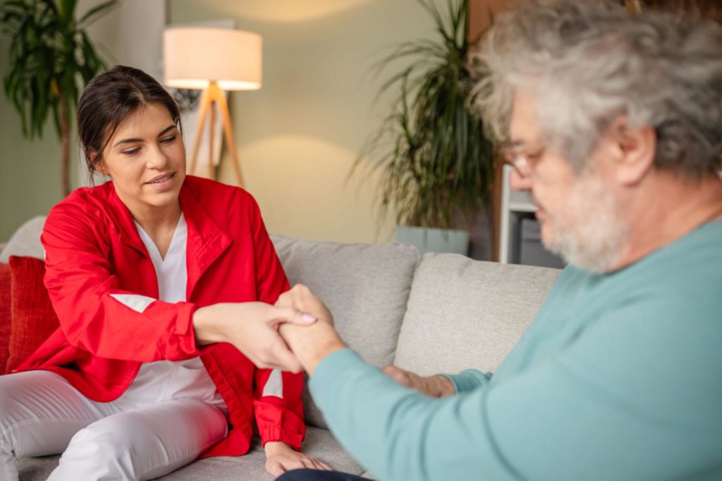 Before an ambulance arrives for someone with dementia, a carer offers calm reassurance at home